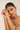 Woman wearing a delicate bracelet on a plain background