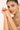 Woman wearing a bracelet on a plain background