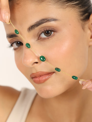 Woman holding a 14K Gold bracelet with natural green gemstones.