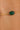 Gold bracelet with a green gemstone on a person's wrist