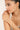 Woman wearing a delicate bracelet on a plain background