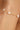 Gold bracelet with pearls on a wrist against a blurred background