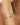 Gold bracelet with colorful beads on a wrist against a neutral background