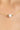Gold necklace with a pearl and green gemstone on a blurred background