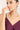 Woman wearing a necklace with a plain background