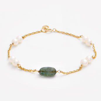 Bracelet with pearls and a green stone on a white background