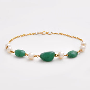 Bracelet with green stones and pearls on a gold chain against a white background