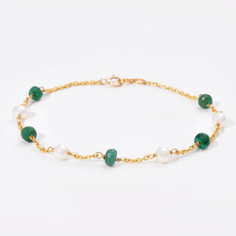 Bracelet with green gemstones and gold chain on a white background