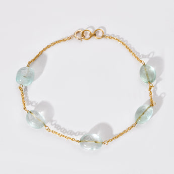 Gold bracelet with white gemstones on a white background
