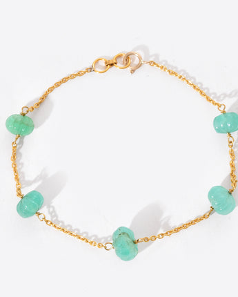 Bracelet with gold chain and turquoise beads on a white background