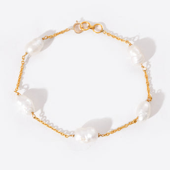 Pearl bracelet with gold chain on a white background