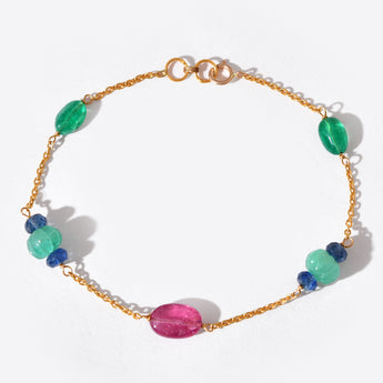 Gold bracelet with colorful beads on a white background