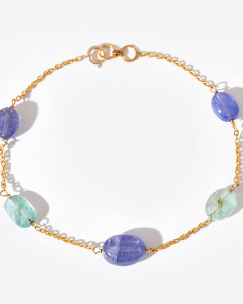Bracelet with gold chain and multicolored beads on a white background