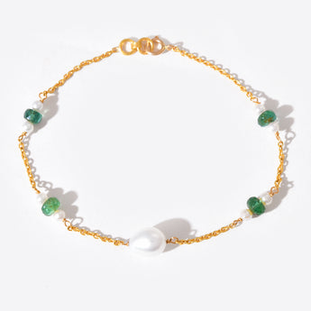 Gold bracelet with green gemstones on a white background