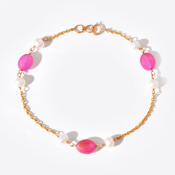 Bracelet with pink gemstones and gold chain on a white background