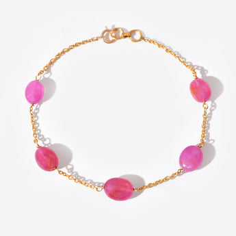 Bracelet with pink beads and gold chain on a white background