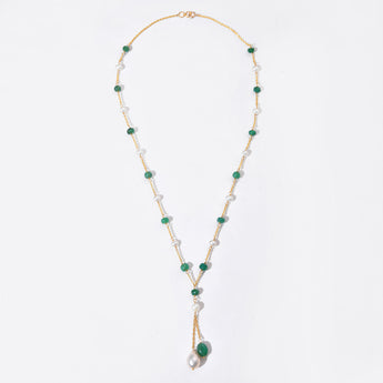 Necklace with green and white beads on a light gray background