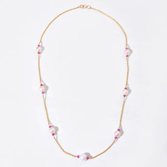 Necklace with pink and white beads on a light gray background