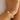 Close-up of a wrist wearing a delicate bracelet with white and red beads.
