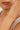 Gold bracelet with white gemstones on a wrist, blurred background