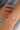 Bracelet with green beads and a pearl on a wrist against a blurred background