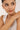 Woman wearing a pearl bracelet on a plain background