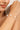 Close-up of a woman's arm wearing a gold bracelet with pearls.