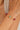 Bracelet with red and green beads on a wrist against a neutral background