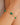 Gold bracelet with green gemstones on a wrist against a neutral background