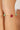 Bracelet with pink and green beads on a wrist against a neutral background