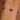 Gold bracelet with red beads on a wrist against a blurred background
