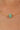 Gold necklace with a green bead on a person's neck