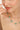 Necklace with green gemstones worn by a woman against a neutral background