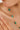 Gold necklace with green gemstones worn by a woman