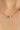 Gold chain necklace with green and pink beads on a woman's neck