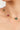 Necklace with green and red beads on a woman's neck against a neutral background