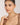 Woman wearing a necklace against a plain background