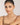 Woman wearing a necklace against a plain background