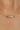 Gold chain necklace with a gemstone on a blurred background