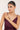 Woman wearing a gemstone bracelet against a plain background