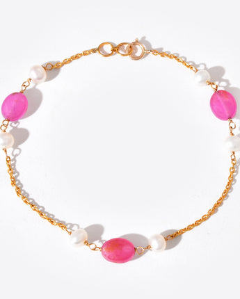 Bracelet with pink gemstones and gold chain on a white background