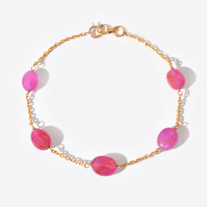 Bracelet with pink beads and gold chain on a white background