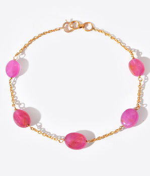 Bracelet with pink beads and gold chain on a white background
