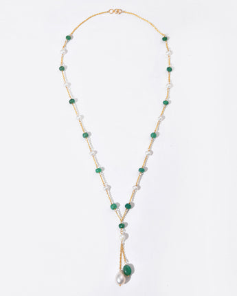 Necklace with green and white beads on a light gray background