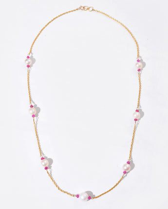 Necklace with pink and white beads on a light gray background