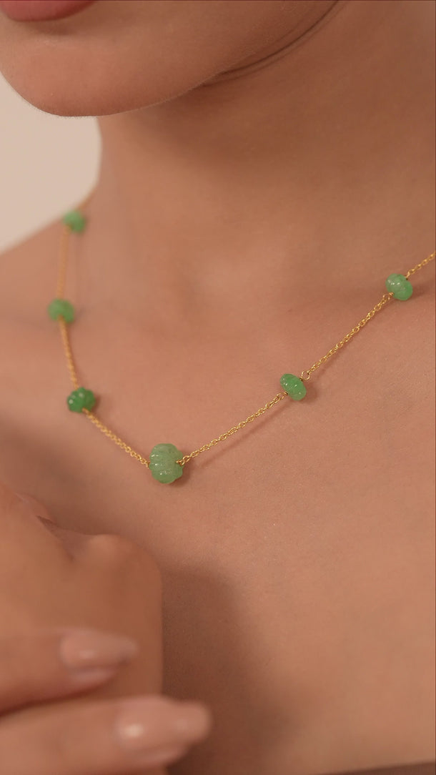 Woman wearing a green gemstones necklace.