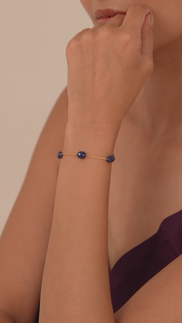 Woman wearing a blue gemstone bracelet on her wrist