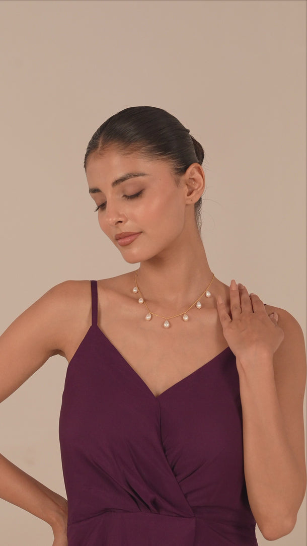 Woman wearing a gold pearl necklace 